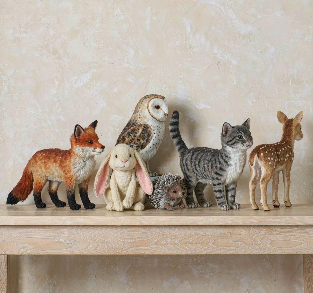 Six realistic plush animals on an oak shelf: fox, rabbit, owl, cat, hedgehog and fawn